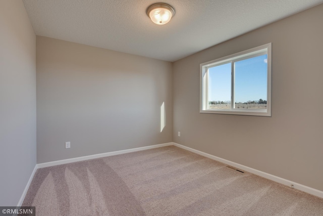 carpeted spare room with a textured ceiling