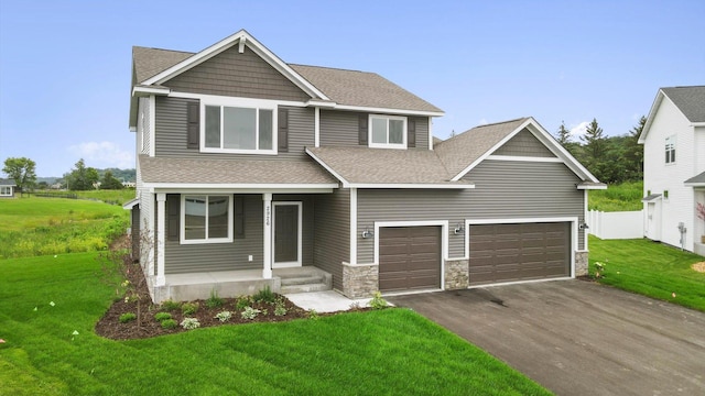 craftsman inspired home featuring a garage and a front yard