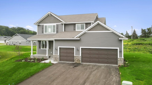 craftsman inspired home featuring a garage and a front lawn