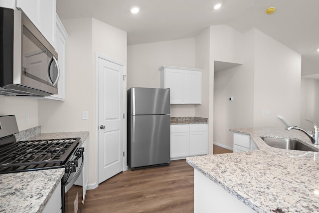 kitchen with white cabinetry, sink, light stone counters, and appliances with stainless steel finishes