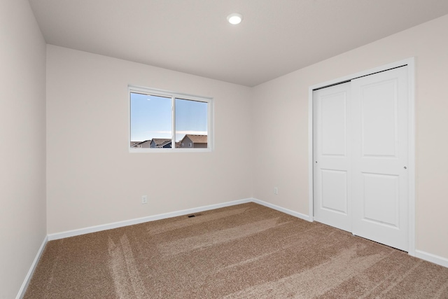 unfurnished bedroom featuring carpet flooring and a closet