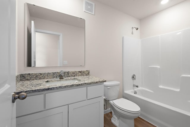 full bathroom featuring vanity, toilet, wood-type flooring, and washtub / shower combination