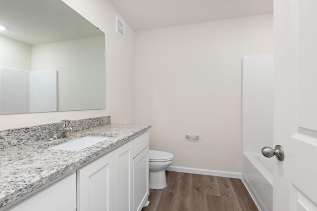 full bathroom with hardwood / wood-style floors, vanity, toilet, and shower / bathing tub combination