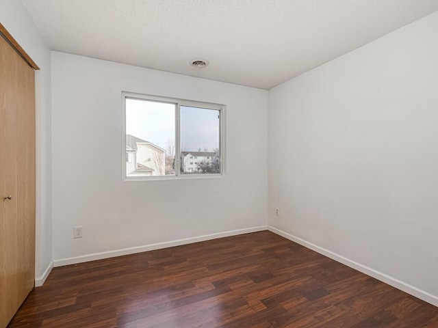 unfurnished bedroom featuring a closet and dark hardwood / wood-style floors