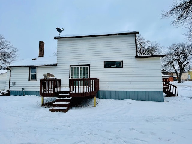 snow covered house with a deck