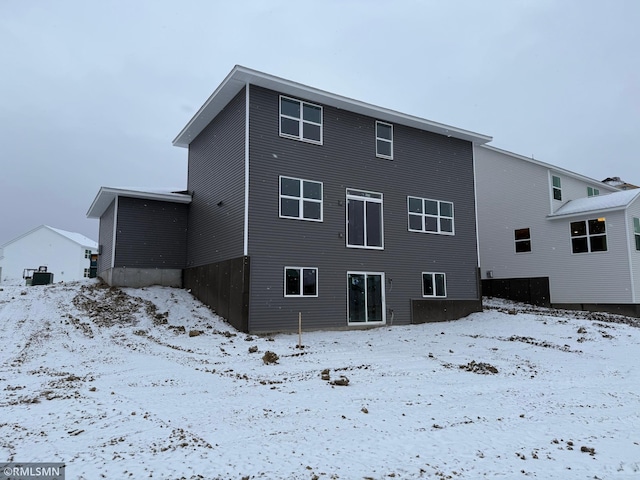 view of snow covered back of property