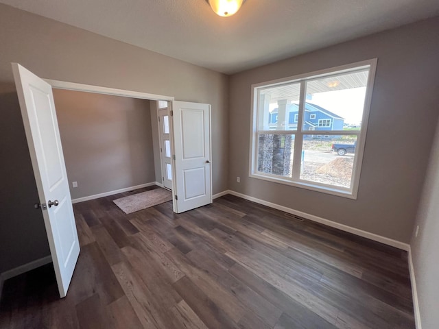 unfurnished bedroom with dark hardwood / wood-style flooring