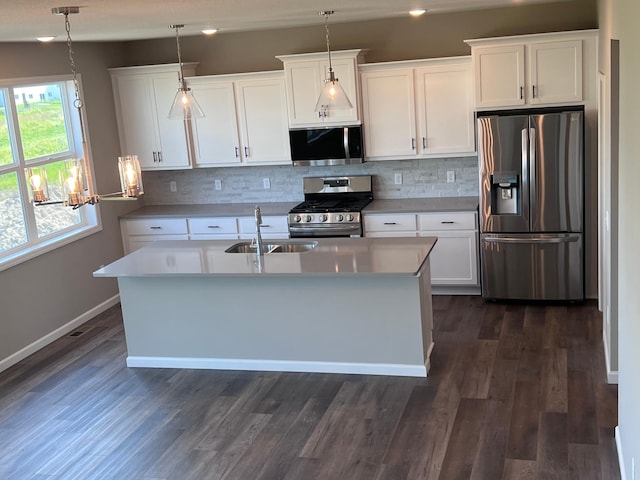 kitchen featuring white cabinets, appliances with stainless steel finishes, and hanging light fixtures