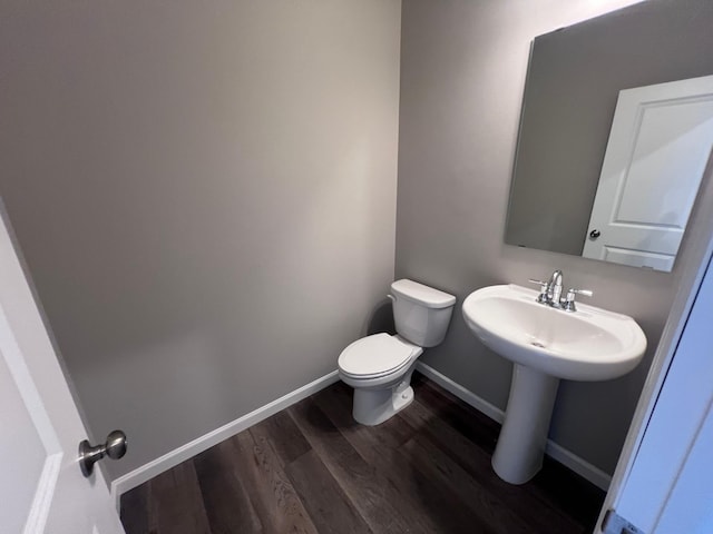 bathroom featuring sink, wood-type flooring, and toilet