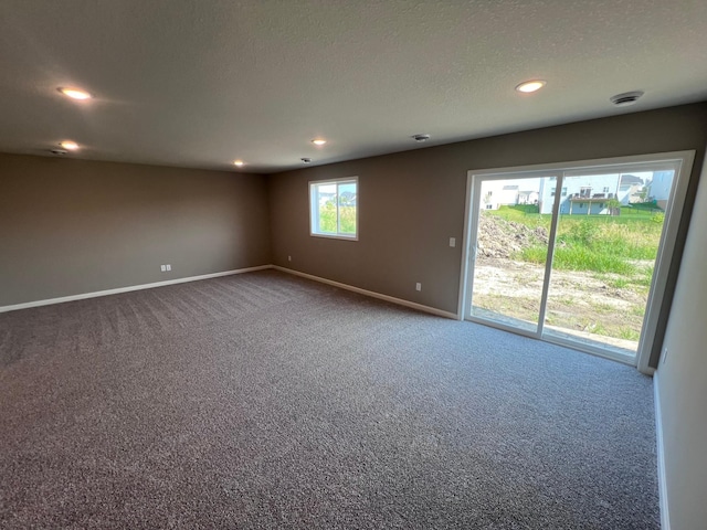 carpeted empty room with a textured ceiling