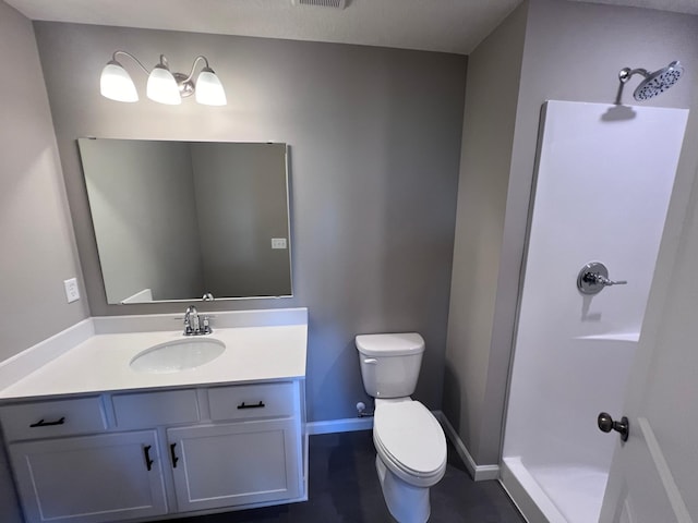 bathroom featuring a shower, vanity, and toilet