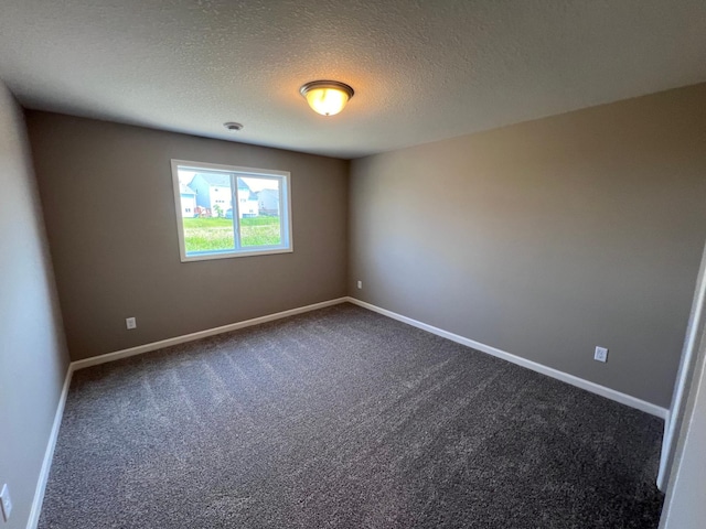 carpeted empty room with a textured ceiling