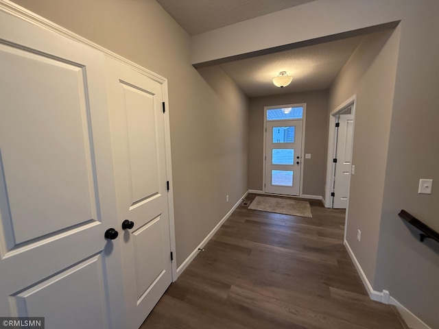 doorway to outside with dark hardwood / wood-style floors and a textured ceiling