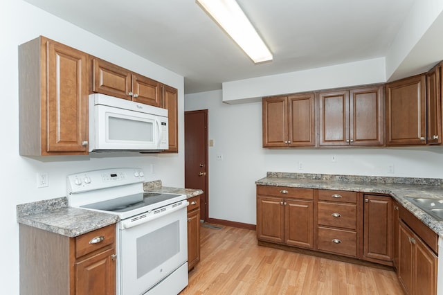 kitchen featuring sink, white appliances, and light wood-type flooring