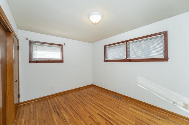 unfurnished room with hardwood / wood-style flooring