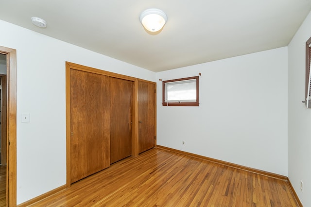 unfurnished bedroom with a closet and light hardwood / wood-style flooring