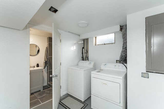 laundry room featuring electric panel and washing machine and clothes dryer