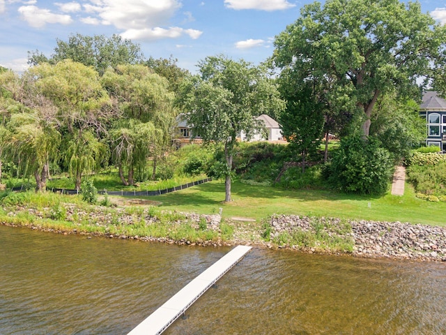 view of dock with a water view and a yard