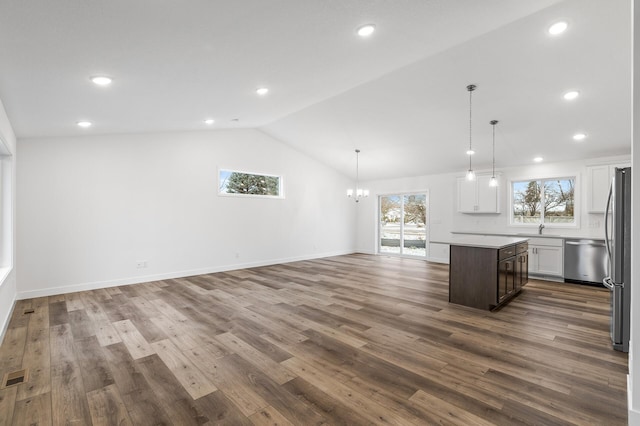 unfurnished living room featuring hardwood / wood-style floors, a chandelier, and lofted ceiling