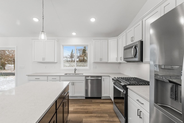 kitchen with white cabinets, appliances with stainless steel finishes, hanging light fixtures, and sink