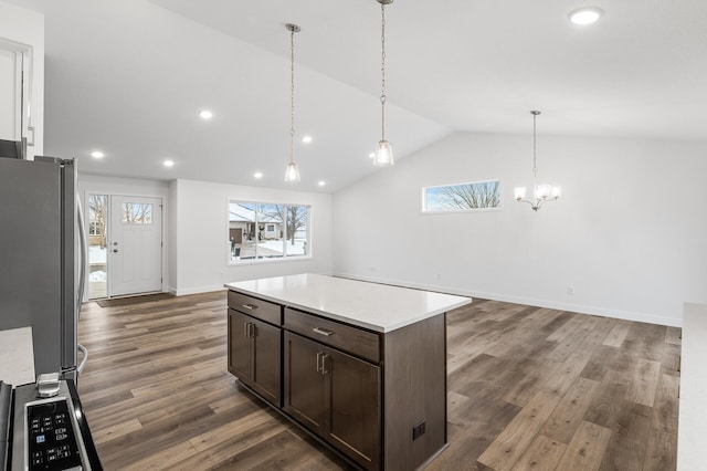 kitchen with stainless steel fridge, decorative light fixtures, dark brown cabinets, and lofted ceiling