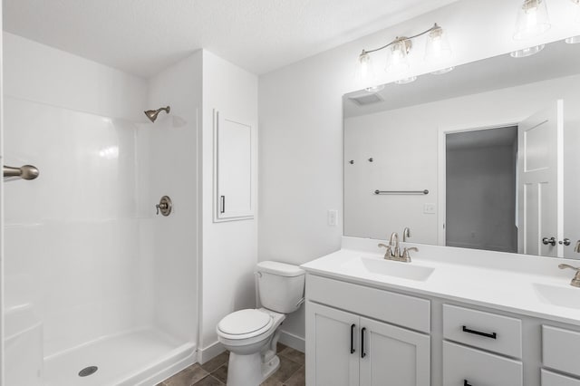 bathroom with a shower, vanity, a textured ceiling, and toilet