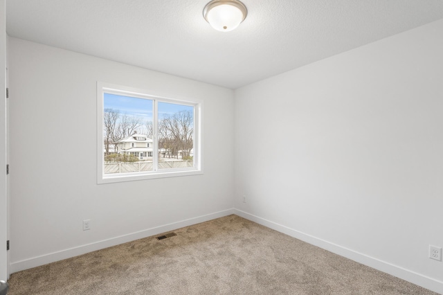 spare room featuring light colored carpet