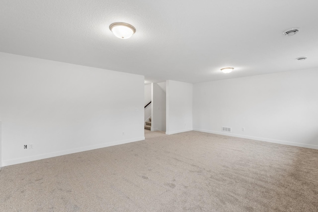 carpeted empty room featuring a textured ceiling