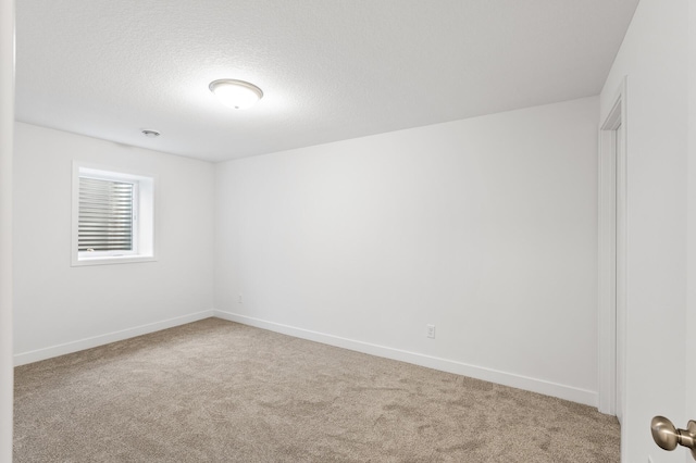 spare room with carpet floors and a textured ceiling