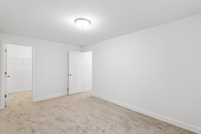 unfurnished room with light carpet and a textured ceiling