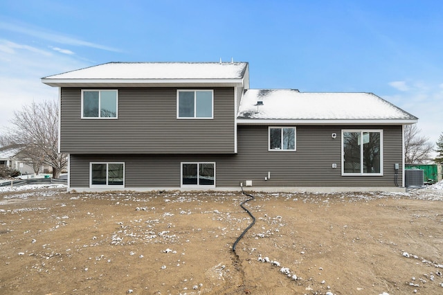 snow covered house featuring central air condition unit