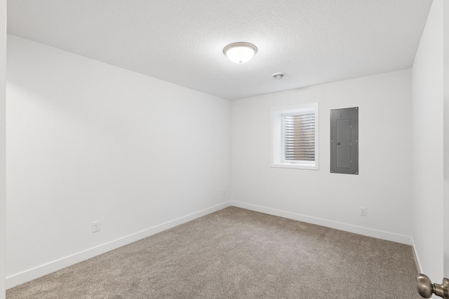 carpeted spare room featuring electric panel, a textured ceiling, and baseboards