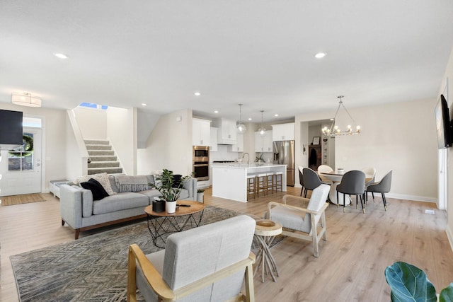 living room featuring a chandelier and light hardwood / wood-style floors