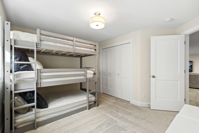 bedroom featuring light colored carpet and a closet