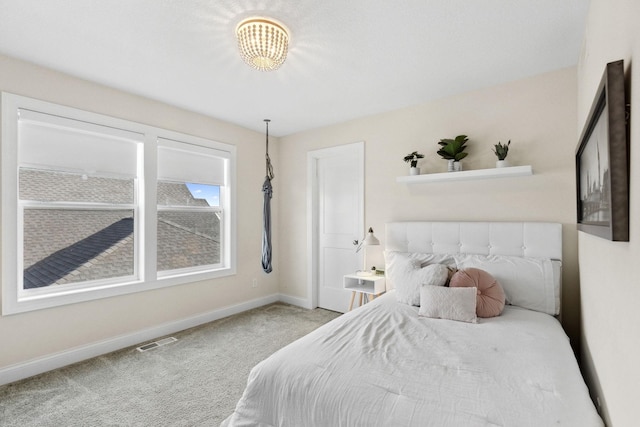 bedroom featuring carpet and a notable chandelier