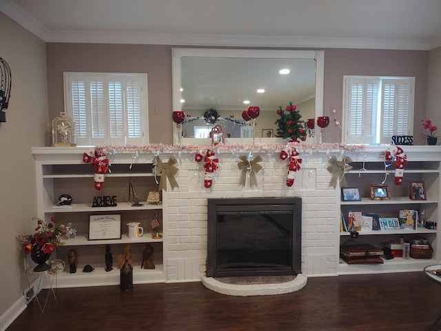 living room featuring ornamental molding, a brick fireplace, and wood finished floors