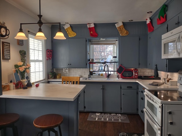 kitchen featuring white appliances, a peninsula, backsplash, healthy amount of natural light, and crown molding
