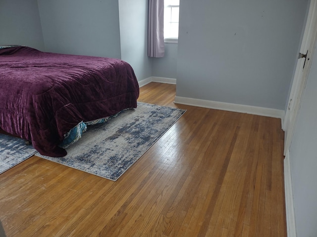bedroom with baseboards and wood-type flooring
