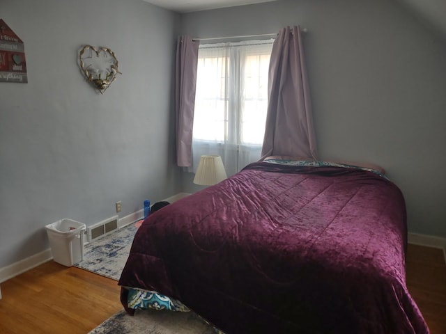 bedroom with baseboards and wood finished floors