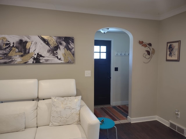 foyer with arched walkways, wood finished floors, and baseboards