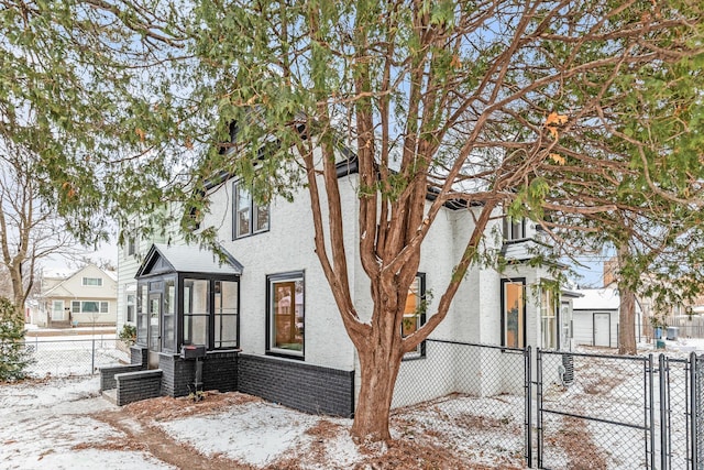 view of snowy exterior featuring a sunroom