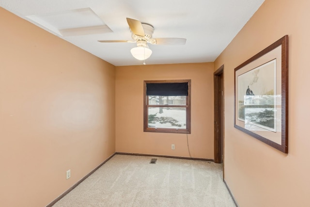 empty room featuring ceiling fan and light carpet