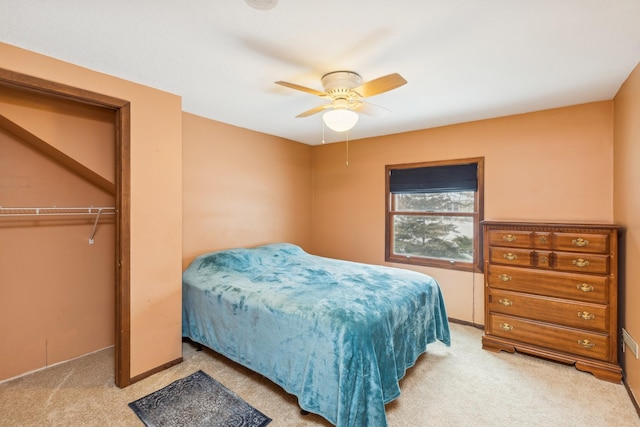 carpeted bedroom featuring ceiling fan and a closet