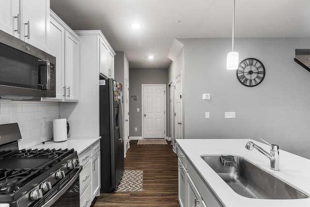 kitchen featuring white cabinets, black range with gas stovetop, hanging light fixtures, sink, and stainless steel refrigerator with ice dispenser