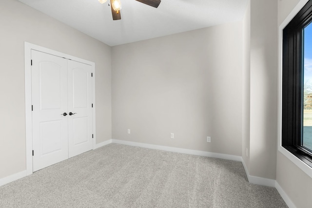 unfurnished bedroom featuring carpet flooring, ceiling fan, and a closet