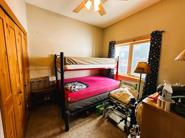 carpeted bedroom with ceiling fan and a closet