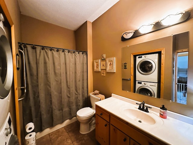 bathroom with toilet, vanity, a shower with curtain, stacked washing maching and dryer, and a textured ceiling