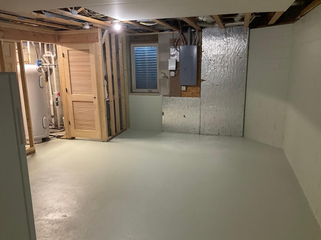 unfinished below grade area with electric panel, water heater, and concrete block wall