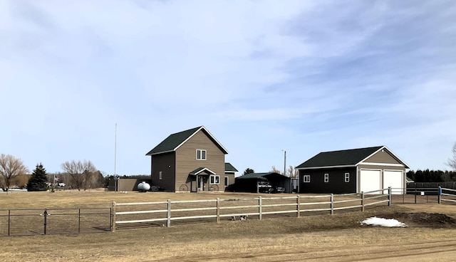 view of yard featuring a rural view, an outdoor structure, and fence