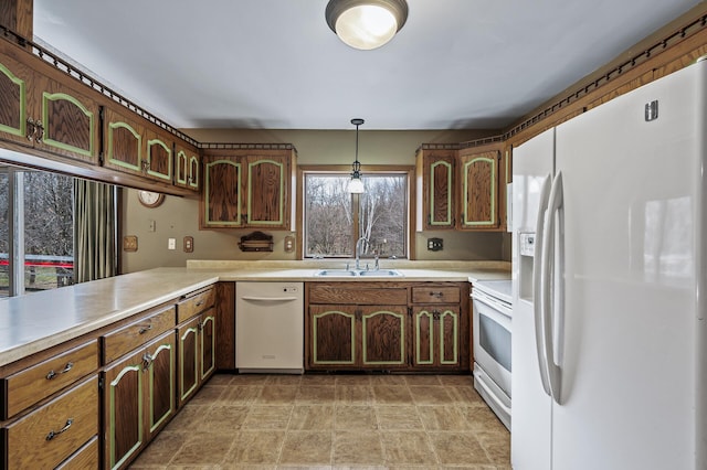 kitchen with white appliances, sink, hanging light fixtures, dark brown cabinets, and kitchen peninsula